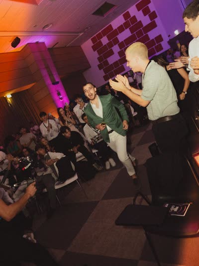 Persone che ballano a una serata della community in una sala con luci viola