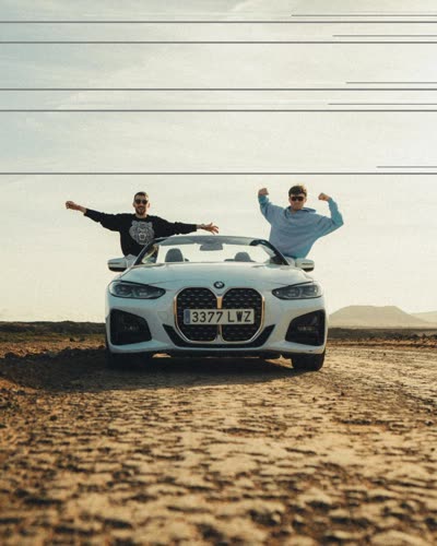 Due ragazzi a braccia aperte sopra una cabriolet bianca nel deserto
